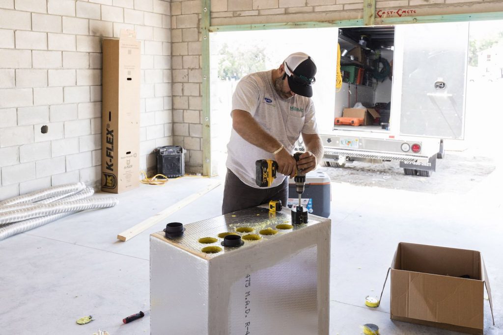 Worker installing take offs into manifold