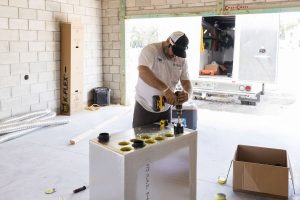 Worker installing take offs into manifold