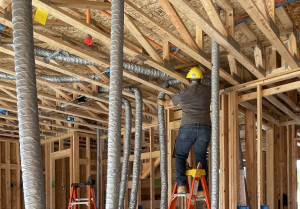 Installer feeding duct through framing